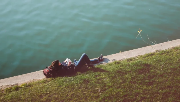 guy laying on edge of river